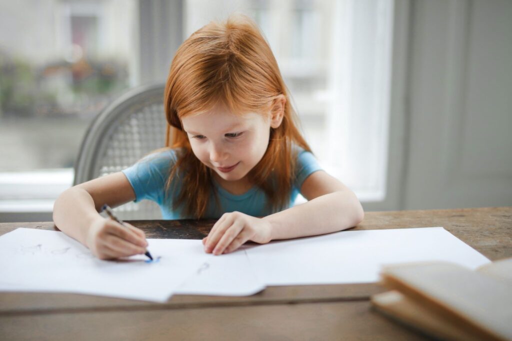 Child coloring on paper.